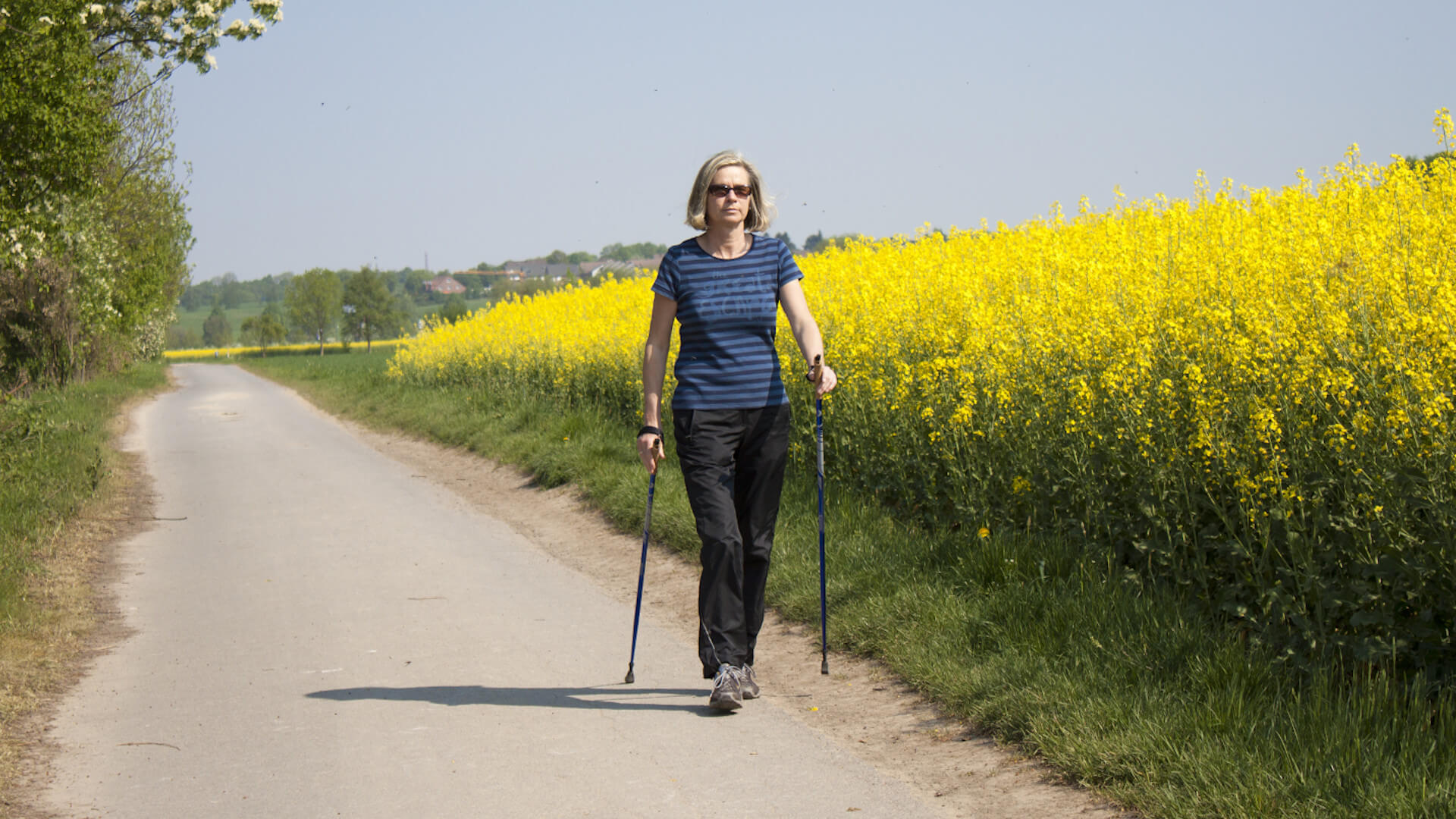 Linksherzinsuffizienz: Frau beim Walken neben einem Rapsfeld.
