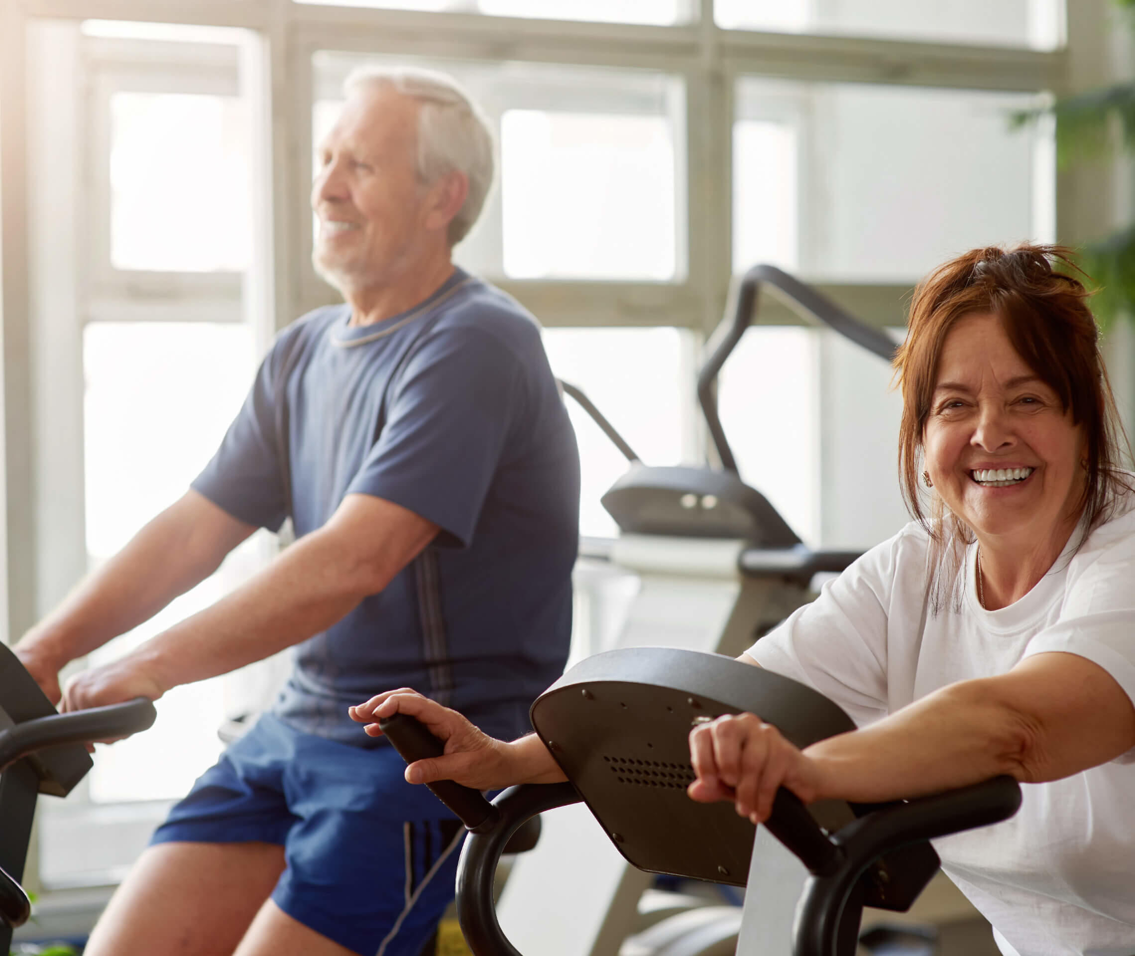 Mann und Frau machen Cardio-Training auf der Reha nach der Bypass-OP.