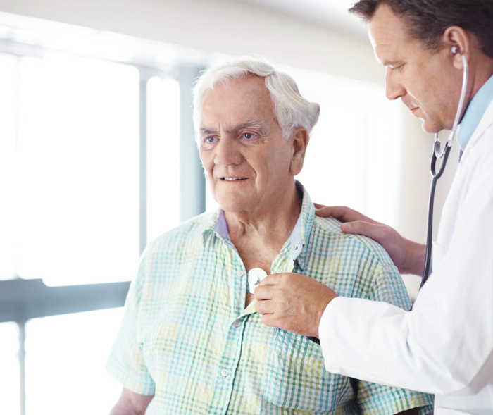 Patient wird vom Arzt im Rahmen einer Herzschwäche-Diagnose (Herzinsuffizienz) abgehört, um einen möglichen Herzklappenfehler auszuschließen.