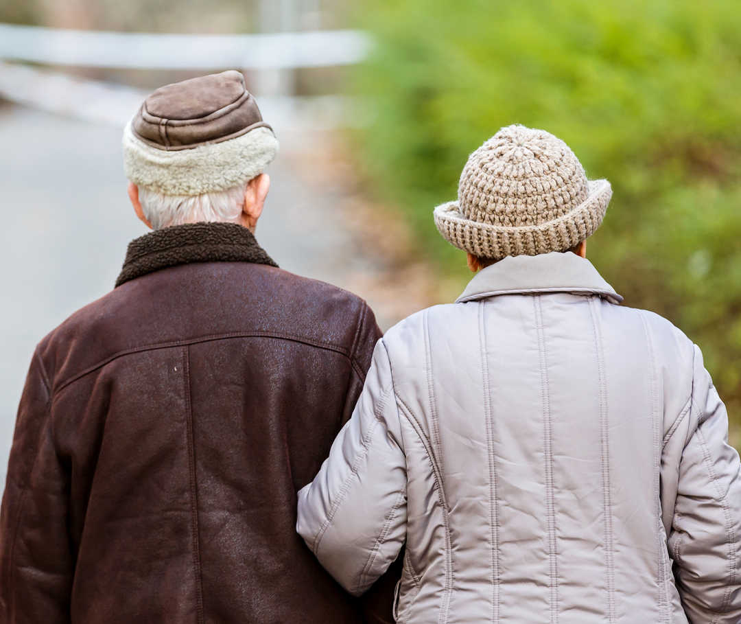 Paar geht spazieren, um das Herz fit zu halten und Herzinsuffizienz vorzubeugen.