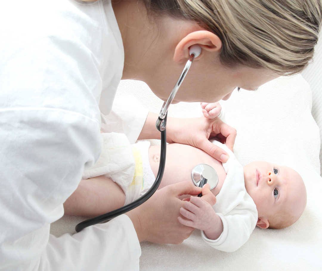 Angeborene Herzfehler: Krankenschwester untersucht Baby.