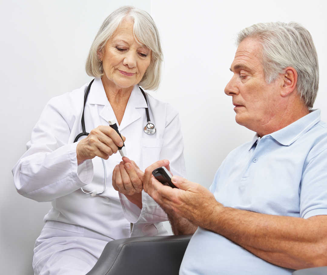 Eine Stoffwechselerkrankung kann eine Herzschwäche auslösen. Eine Ärztin führt bei einem Patienten eine Blutzuckermessung durch, um eine Stoffwechselerkrankung festzustellen.