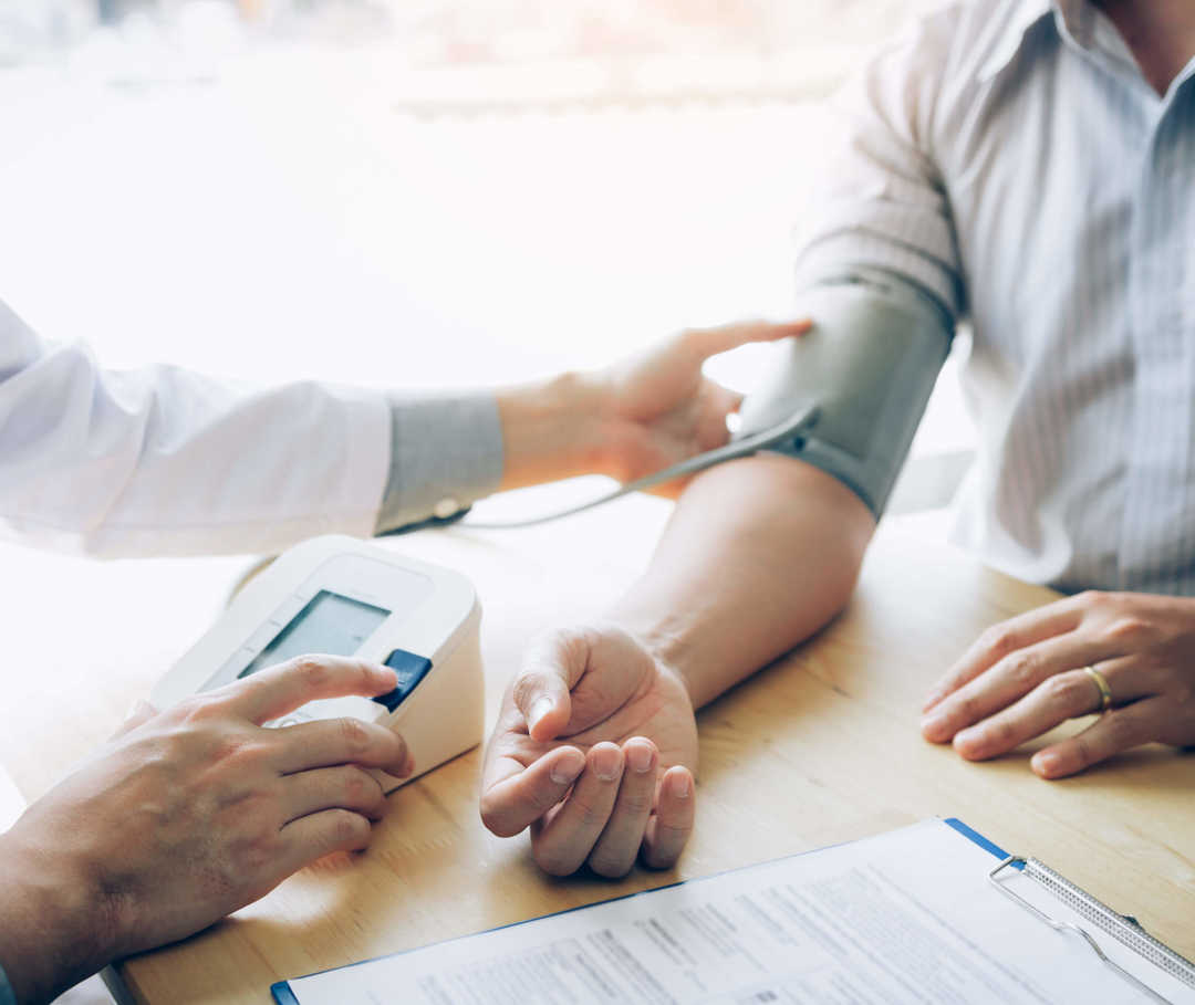 Arzt misst den Blutdruck eines Herzinsuffizienz-Patienten, um zu sehen, ob er unter der Begleiterkrankung Bluthochdruck leidet.