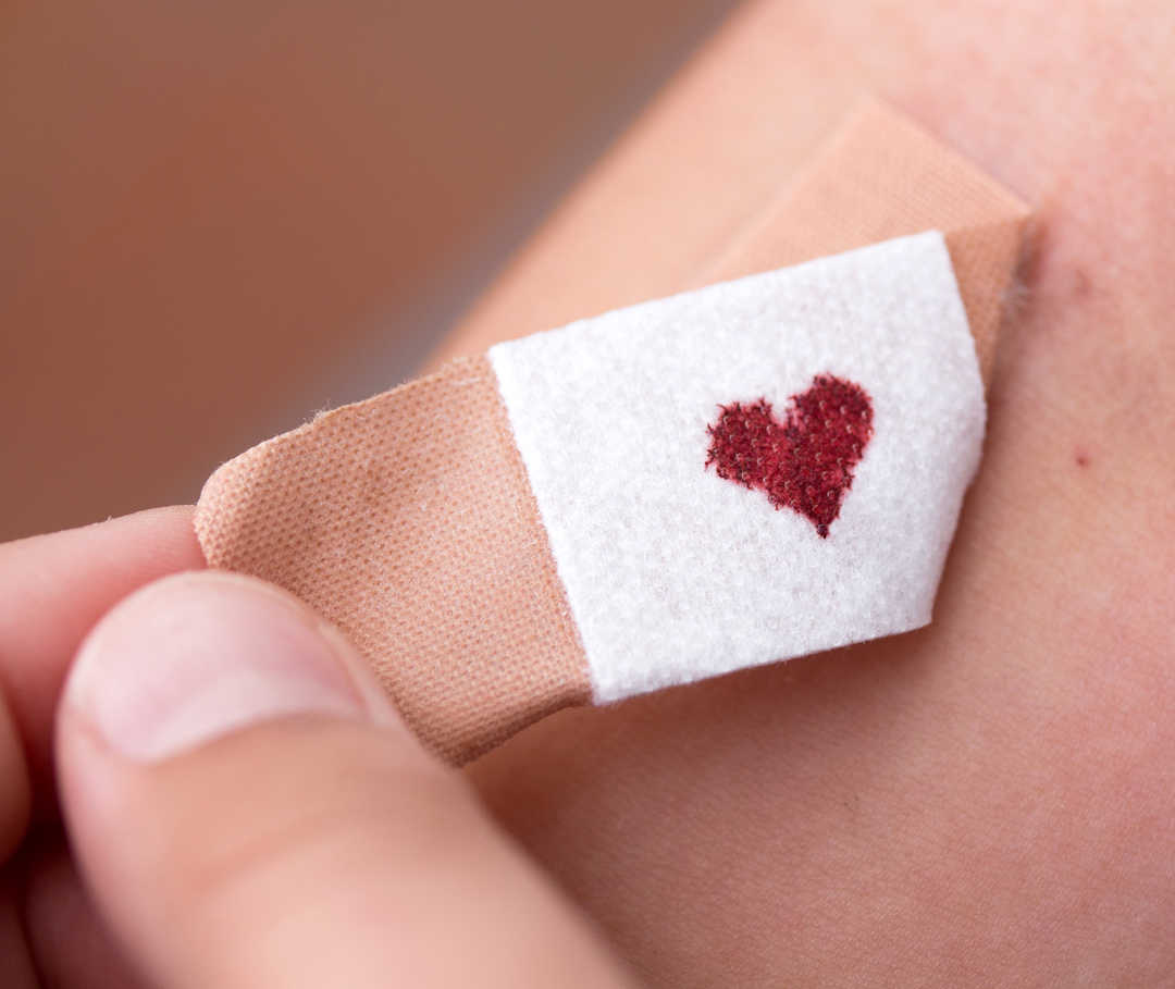 Ein Pflaster mit einem Blutstropfen in Herzform.