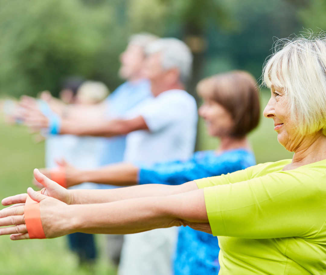 Sport bei Herzinsuffizienz fällt in Gruppen oft leichter. Sport bei Herzinsuffizienz ist wichtig für die Gesundheit: Senioren trainieren im Grünen.