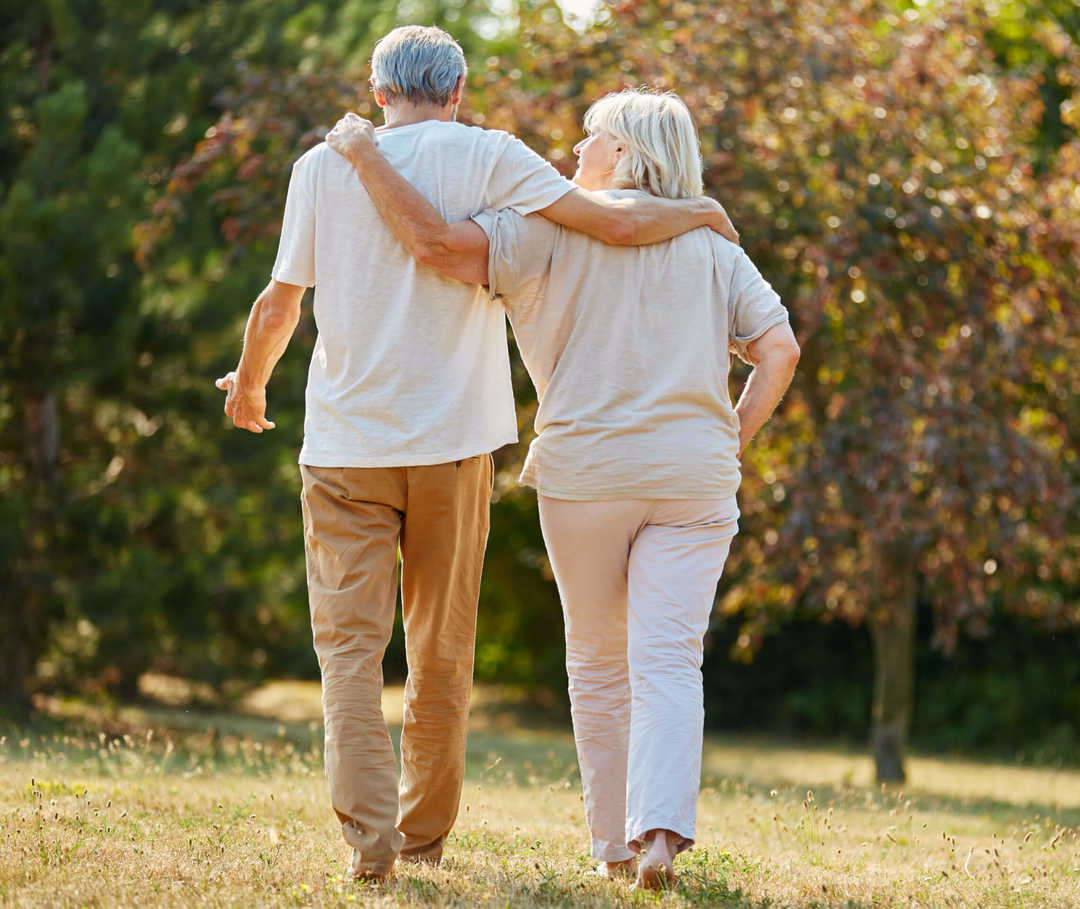 Paar geht trotz Aortenklappeninsuffizienz in der Natur spazieren.