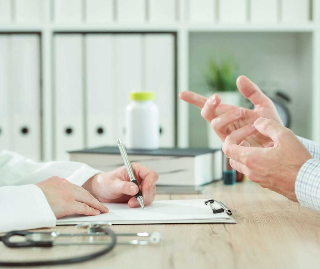 Vor der ICD-Implantation werden Betroffene über die OP aufgeklärt. Stethoskop und EKG-Daten: Arzt klärt Patienten über ICD-Implantation auf.