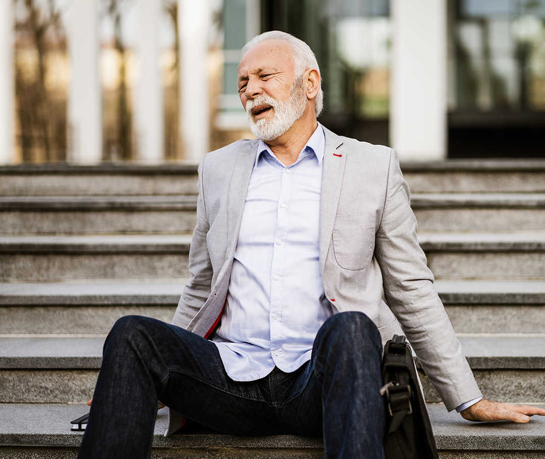 Mann sitzt erschöpft auf der Treppe, da er durch COPD schwer atmen kann.