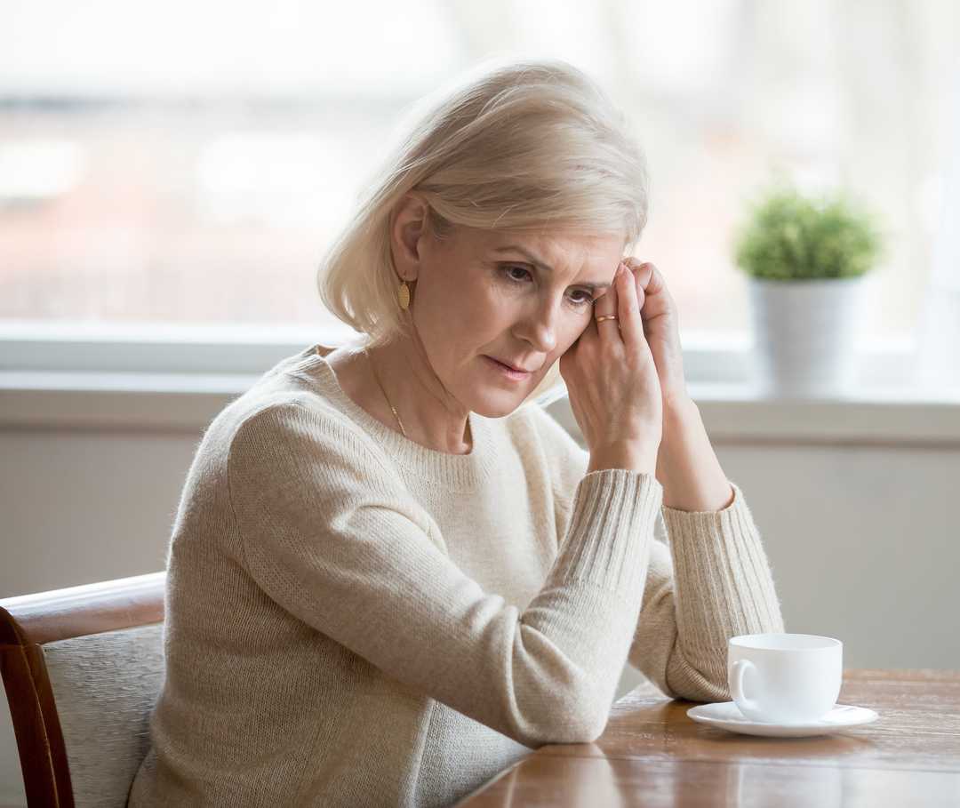 Nachdenkliche ältere Frau fragt sich, inwieweit ihr die Psychokardiologie zu mehr Wohlbefinden verhelfen kann.