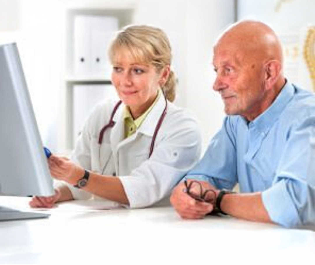Kardiologen und Kardiologinnen beraten zur Herzgesundheit. Ärztin erklärt Patient auf dem PC-Bildschirm, wie seine Erkrankung zustande kommt und was die bestmögliche Therapie ist.