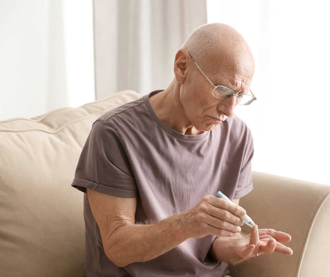 Diabetes und Herzinsuffizienz: Mann misst seinen Blutzuckerwert.