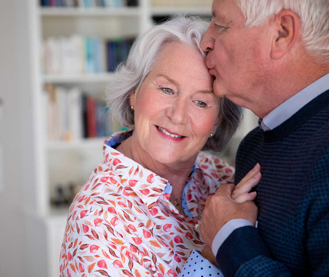 Sex bei Herzinsuffizienz: Mann hält seine Frau mit Herzinsuffizienz im Arm – sie sind glücklich, da die Erkrankung ihr Sexualleben nicht einschränkt.